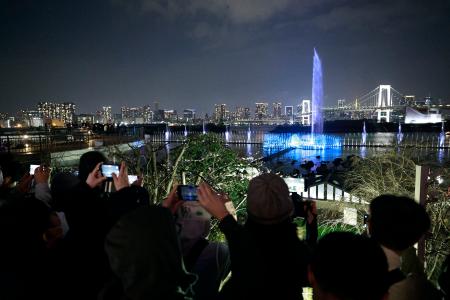 　「東京アクアシンフォニー」の上演にスマートフォンを向ける大勢の人たち＝２８日夜、東京都港区