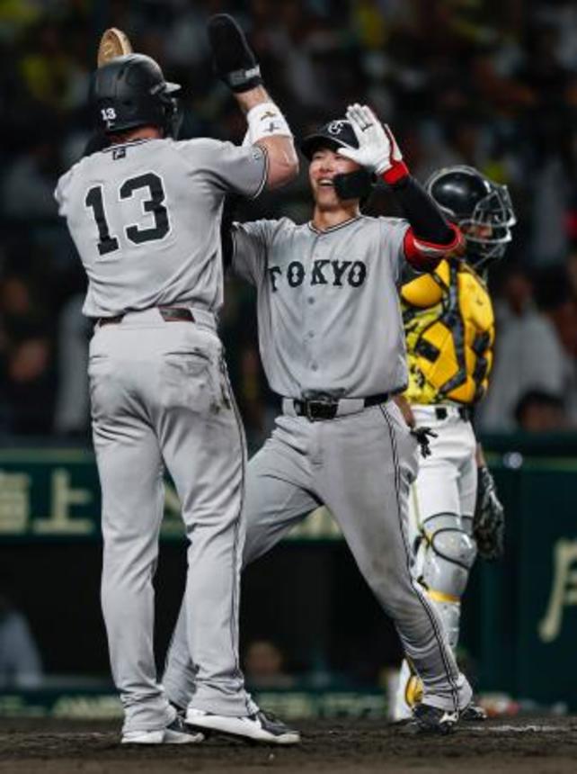 　１０回、決勝２ランを放ちキャベッジ（１３）に迎えられる巨人・小浜＝甲子園