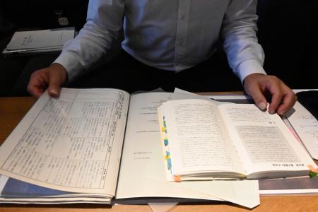 　いじめに関する資料を手に、取材に応じる男子生徒の父親＝４日、大津市