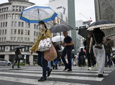 　東京・銀座を傘を差して歩く人たち。都心で連続降雨過去最長を記録した＝２９日午前
