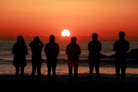 　東日本大震災から１５年、仙台市若林区荒浜地区の海岸で朝日を見る人たち＝１１日午前５時５７分