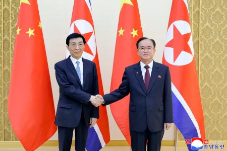 　北朝鮮の趙甬元・朝鮮労働党書記（右）と握手する中国共産党序列４位の王滬寧・人民政治協商会議主席＝１５日、平壌（朝鮮中央通信＝共同）