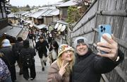 　京都・清水寺近くの二年坂で記念撮影する訪日客＝１月
