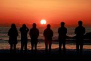 　東日本大震災から１５年、仙台市若林区荒浜地区の海岸で朝日を見る人たち＝１１日午前５時５７分