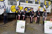  実証実験開始を記念して給油とテープカットをする関係者＝恵那市明智町、明智駅 