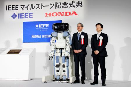 　埼玉県和光市で開かれた式典で、ホンダの人型ロボット「ＡＳＩＭＯ（アシモ）」の前身となったロボット「Ｐ２」と並ぶ三部敏宏社長（左）ら＝２８日午前