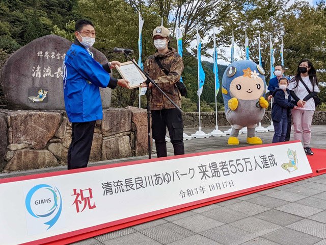 長尾安博県農政部長から認定証を受け取る男性（中央）ら＝郡上市白鳥町長滝、清流長良川あゆパーク