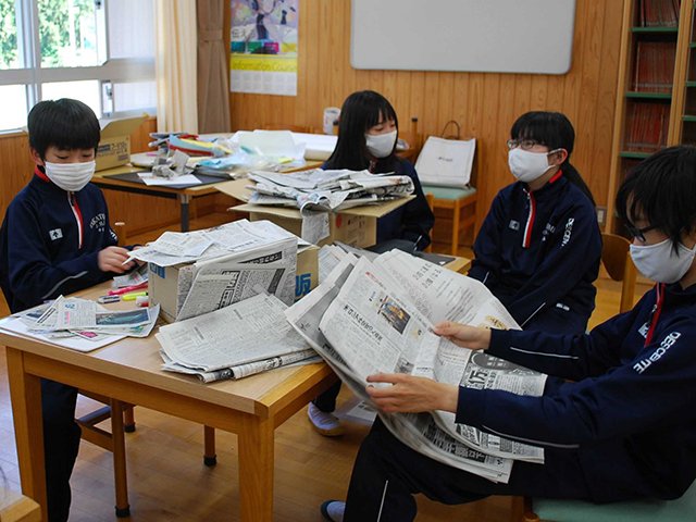 新聞を読んで考えを深める新聞部員＝山県市高富、高富中学校