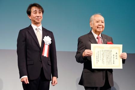 　全日本スキー連盟の創立１００周年記念式典に出席した原田雅彦会長。右は猪谷千春さん＝３１日、東京都港区