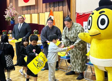 　小梅小学校を訪問し、ランドセルカバーを配る桐山親方（左端）ら＝８日、東京都墨田区