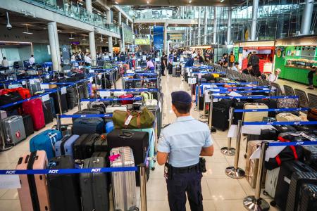 　タイ・バンコク近郊のスワンナプーム国際空港で、大量の荷物のそばに立つ警備員＝２９日（ロイター＝共同）