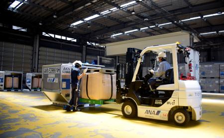 　貨物用コンテナに収容される備蓄米＝３０日午前、東京都大田区