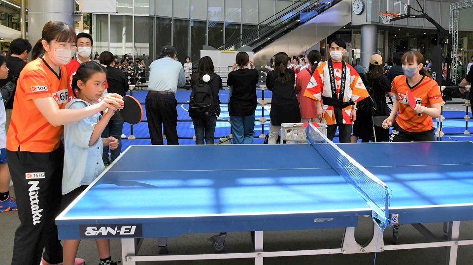 選手から手ほどきを受けながら卓球を楽しむ子どもら＝岐阜市徹明通、柳ケ瀬グラッスル３５