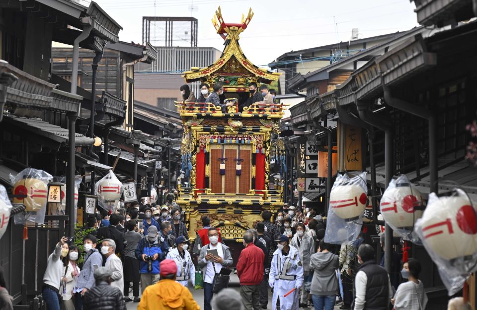開幕した春の高山祭で、雨間をついて古い町並みを進む祭り屋台＝１４日午後２時４１分、岐阜県高山市内