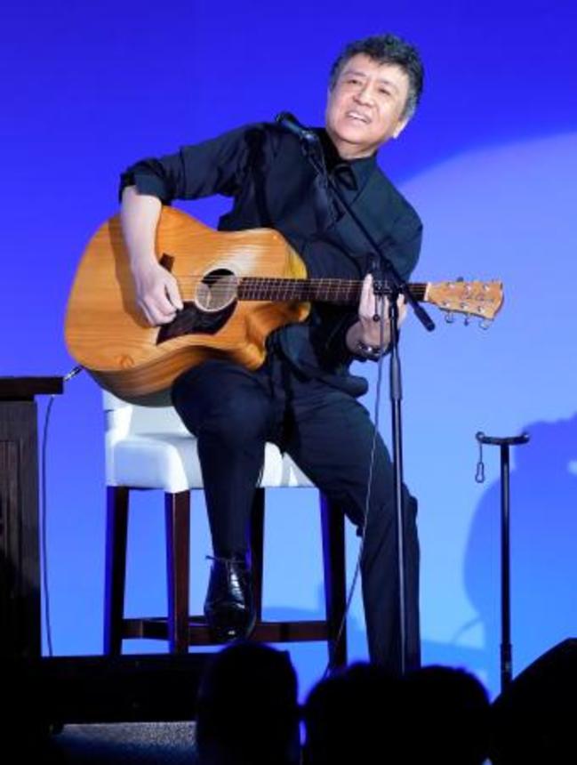 　自民党大会に特別ゲストとして登場し、弾き語りする音楽家の世良公則さん＝１２日午前、東京都内