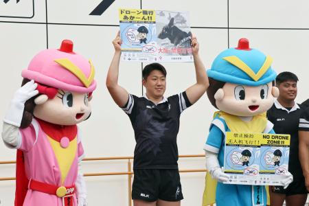　万博会場でのドローン飛行規制について、啓発イベントを行う大阪府警の警察官＝１８日午後、大阪メトロ夢洲駅