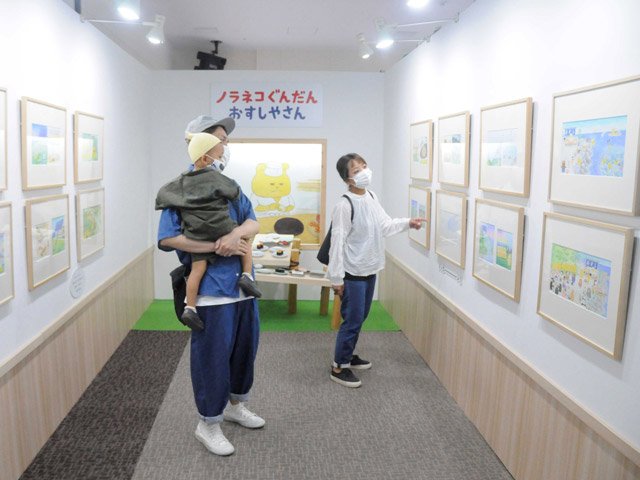 「ノラネコぐんだん」の原画を楽しむ親子＝岐阜市正木中、マーサ２１