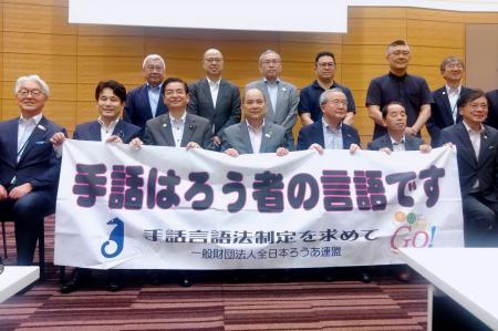 　報告会で記念撮影する全日本ろうあ連盟の関係者ら＝１９日午後、国会
