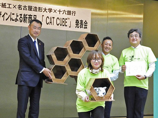 産学連携で開発した段ボール製のキャットハウスをＰＲする長井浩司社長（後列中央）ら＝岐阜市神田町、十六銀行本店