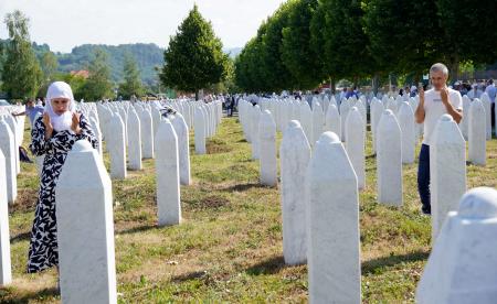 　虐殺の犠牲者の記念墓地で、祈りをささげる人たち＝１１日、ボスニア・ヘルツェゴビナ東部スレブレニツァ近郊（共同）