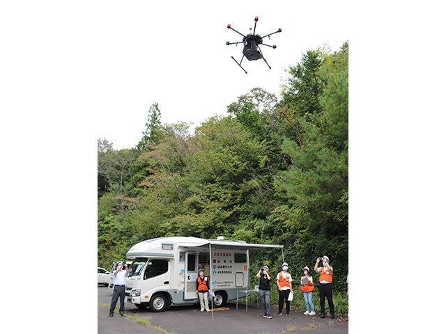 モバイルファーマシーの前で飛び立つ医薬品を積んだドローン＝岐阜市山県北野、岐阜ファミリーパーク
