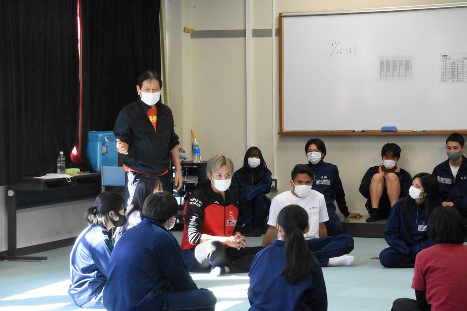生徒たちにゲームを説明する西川信廣さん（左）＝可児郡御嵩町御嵩、東濃高校