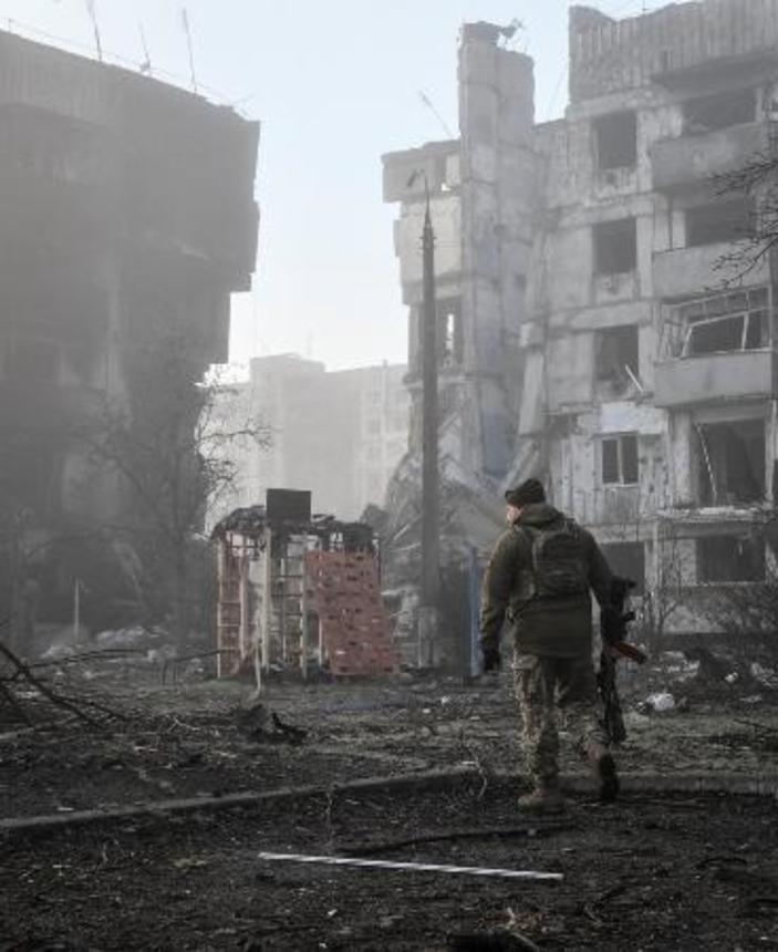 　ロシア軍の攻撃を受けた住宅近くを歩くウクライナ兵＝３月、ウクライナ南部ザポリージャ州オリヒウ（ロイター＝共同）