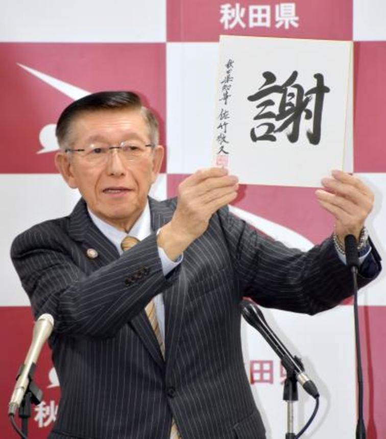 　４期目満了での引退に合わせて記者会見し、県民へのメッセージ「謝」を掲げる秋田県の佐竹敬久知事＝１８日午後、秋田県庁