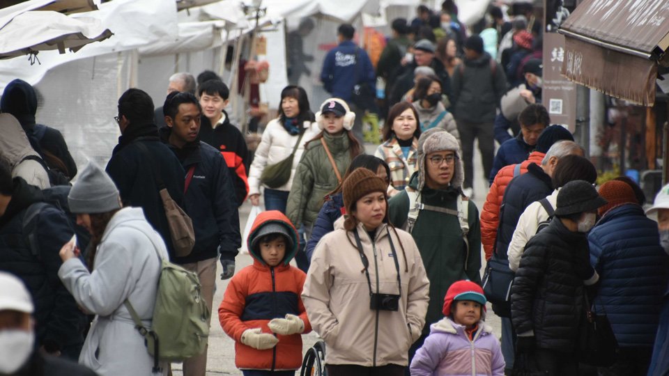 厚手の上着などを着込んだ観光客らでにぎわう飛騨高山宮川朝市＝２１日午前９時５４分、高山市下三之町