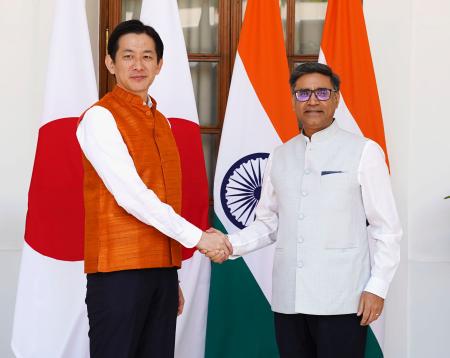 　インドのミスリ外務次官（右）と握手する自民党の小林政調会長＝４日、インド・ニューデリー（共同）