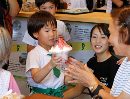 　１日限りの「かき氷屋」で配膳する綾部世渚ちゃん＝１７日午前、福島県双葉町
