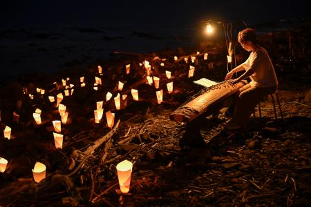 　「三船遭難事件」の犠牲者を悼み行われた送り火と演奏＝１６日夜、北海道留萌市