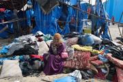 　１７日、ガザ中部デールバラハで、イスラエルの攻撃を受けた現場で座り込む女性（ロイター＝共同）