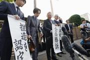 　大川原化工機訴訟の東京高裁判決を受け、「全面勝訴」と書かれた紙を手にする大川原正明社長ら＝５月、東京高裁前