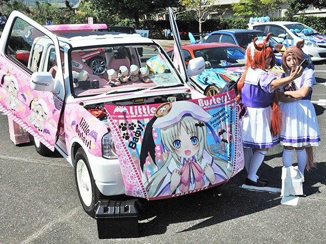 痛車と記念撮影をするコスプレをした来場者＝同