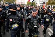 　２４日、デモ隊を警戒する警察官＝パリ（共同）