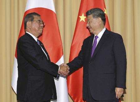 　２０２４年１１月、首脳会談を前に握手する石破首相（左）と中国の習近平国家主席＝ペルー・リマ（共同）
