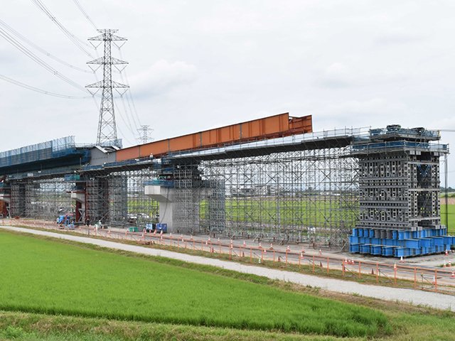 東海環状自動車道西回りルートの工事で、ゆっくりと進む橋桁＝７月２９日、海津市南濃町志津新田