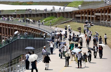 　大阪・関西万博会場で、日傘を差して大屋根リングの上を歩く来場者＝３０日午後、大阪市此花区の夢洲
