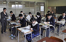 どの面にどんな内容の記事が載っているのかを確認する生徒たち＝高山市下岡本町、飛騨高山高校