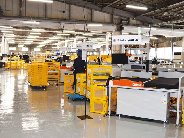 印刷機と共に、自動仕分け機（手前）などの物流機器も配備した工場＝多治見市旭ケ丘、イメージ・マジック岐阜プリントセンター