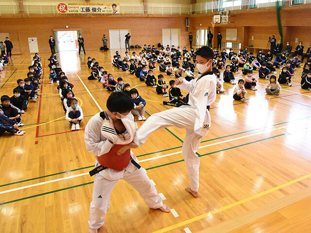 子どもらの前で技を披露する工藤俊介選手（右）＝恵那市武並町、武並小学校