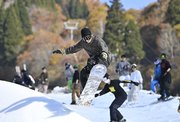 紅葉を背に初滑りを楽しむスノーボーダー＝３日午前１０時４２分、郡上市白鳥町石徹白、ウイングヒルズ白鳥リゾート