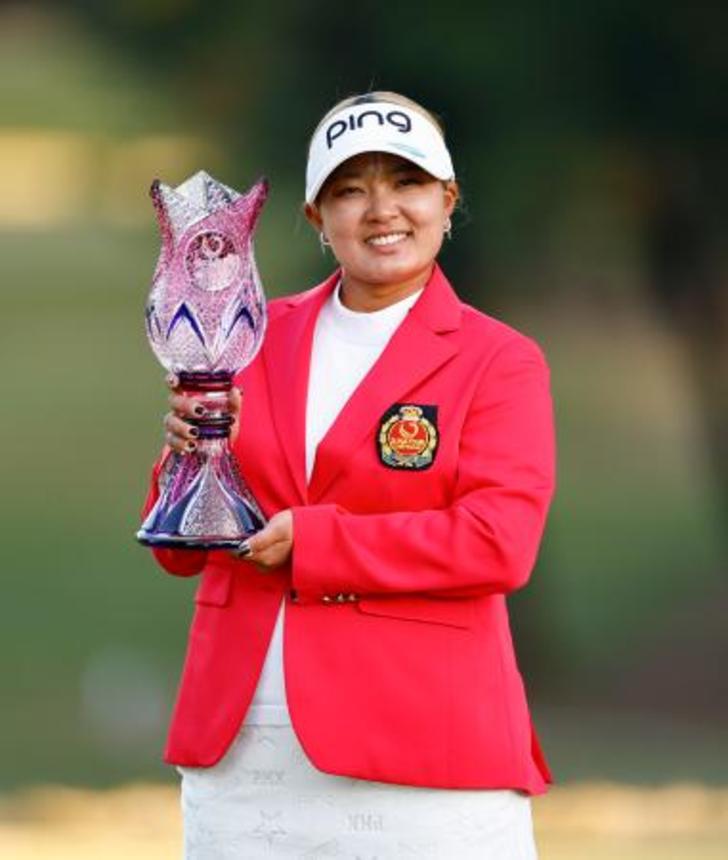 　プレーオフを制して優勝し、トロフィーを手に笑顔の鈴木愛＝宮崎ＣＣ