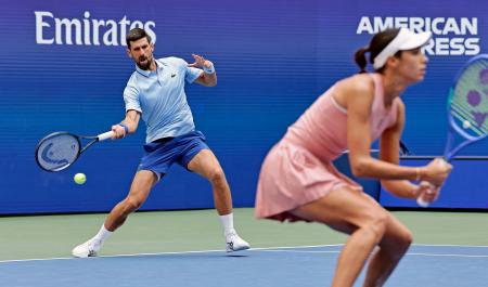 　混合ダブルス１回戦でプレーするノバク・ジョコビッチ（左）、オルガ・ダニロビッチ組＝ニューヨーク（共同）