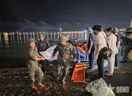 　観光船が転覆したベトナムのハロン湾で、担架で運ばれる犠牲者＝１９日（ＱＤＮＤ提供・ＡＰ＝共同）