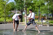 うだるような暑さの中、学校帰りに水遊びをする男子高校生＝２８日午後３時４０分、多治見市音羽町、虎渓用水広場