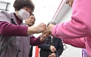 県議選が告示され、立候補者（右）とグータッチを交わす有権者＝３１日午前１０時４分、岐阜県多治見市内