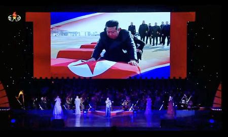 　ロ朝芸術団の公演のスクリーンに投影された、北朝鮮の国旗に包まれたひつぎに向かう金正恩朝鮮労働党総書記。朝鮮中央テレビが３０日に放映した（共同）