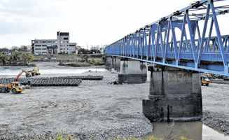 川島大橋付近で増水時に工事現場を守るための土のうを設置する重機＝２０２１年１２月、各務原市川島笠田町